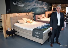 Accountmanager Bram Kropmans van Van Landschoot Bedding poseert bij een nieuw FJØRD boxspring.